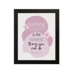 Christian wall art featuring the quote Getting Wisdom Is The Wisest Thing You Can Do from Proverbs 4:7, with pink flowers and soft colors. hung on the wall in a black frame