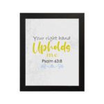 Christian wall art featuring the phrase Your Right Hand Upholds Me in playful fonts with a yellow cursive style and decorative waves. hung on the wall in a black frame