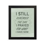 Christian wall art with the phrase I Still Remember The Days I Prayed For What I Have Now on a light green background. hung on the wall in a black frame