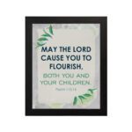 Infidu Christian wall art featuring Psalm 115:14 with bold text, green highlights, and leaf designs on a light gray background. hung on the wall in a black frame