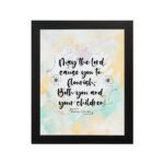 Christian wall art featuring Psalm 115:14 in black cursive on a pastel watercolor background with floral designs. hung on the wall in a black frame