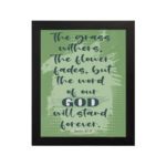 Christian wall art featuring Isaiah 40:8 with dark green and black text on a light green background. hung on the wall in a black frame