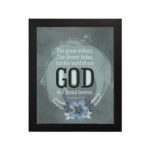 Isaiah 40:8 Christian wall art with light gray and white text on a muted blue background, featuring "GOD" in bold letters. hung on the wall in a black frame