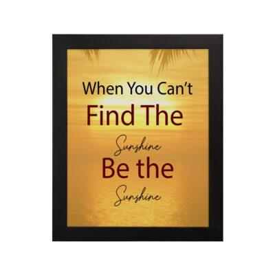 Infidu When You Can't Find The Sunshine Be The Sunshine wall art with a yellow background brown text and black frame hung on the wall. perfect for inspiring positivity in any workspace.