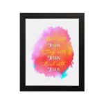 Bible wall art featuring Start With Jesus, Stay With Jesus and End With Jesus in white and orange fonts over a pink, orange, and yellow watercolor background. hung on the wall in a black frame