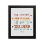 Bible wall art with Acts 2:21 verse, featuring pastel polka dots and bold text, designed to inspire and uplift your home decor. hung on the wall in a black frame