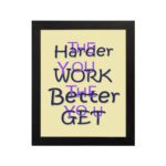 Infidu The Harder You Work The Better You Get wall art with a light sandal background dark blue and violet text and a black frame hung on the wall. Inspiring decor for home offices and workspaces.