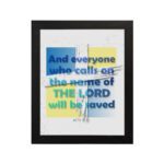 Acts 2:21 Bible Verse Wall Art with bold fonts and light blue highlights on "The Lord" against a textured white and yellow background. hung on the wall in a black frame