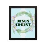 Infidu Jesus Christ Bible Wall Art with JESUS CHRIST text in a mint blue background surrounded by a floral wreath. hung on the wall in a black frame