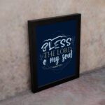 Infidu wall art featuring Bless The Lord O My Soul Psalm 103:1 in gold and white text on a dark blue background with decorative leaves. displayed on the wall in a black frame