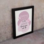 Christian wall art featuring the quote Getting Wisdom Is The Wisest Thing You Can Do from Proverbs 4:7, with pink flowers and soft colors. displayed on the wall in a black frame