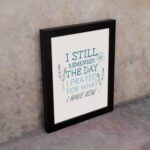 Christian wall art featuring the phrase I Still Remember The Days I Prayed For What I Have Now with floral designs in light blue. displayed on the wall in a black frame