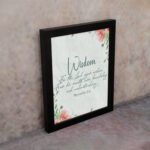 Christian wall art with Proverbs 2:6, featuring "Wisdom" and floral accents on a cream background. displayed on the wall in a black frame