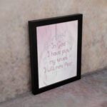 Christian wall art featuring Psalm 56:4, with soft pink background and elegant script font. Perfect for home decor. displayed on the wall in a black frame