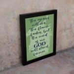 Christian wall art featuring Isaiah 40:8 with dark green and black text on a light green background. displayed on the wall in a black frame