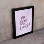 His Grace Is Enough Bible Wall Art with purple text on a lilac background. displayed on the wall in a black frame