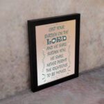 Cast Your Burden on the Lord Psalm 55:22 Bible verse wall art with teal lettering and soft peach background, Christian home decor. displayed on the wall in a black frame