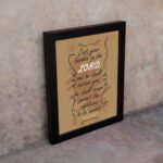 Christian wall art featuring Psalm 55:22, with a warm brown background, dark text, and elegant scrollwork. Perfect for home decor. displayed on the wall in a black frame