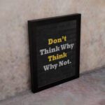 Infidu Don't Think Why, Think Why Not wall art with a black background yellow and white text, and a black frame on the wall. Inspiring decor for home offices and workspaces.