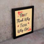 Infidu Don't Think Why, Think Why Not wall art with a red design sandal background and black frame on the wall. Inspiring decor for home offices and workspaces.