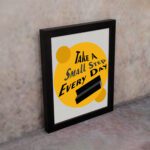 Infidu Take A Small Step Everyday wall art with a gray and yellow background black text and black frame on the wall. Inspiring decor for any workspace.