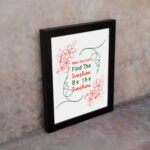 Infidu When You Can't Find The Sunshine Be The Sunshine wall art with a white background and red floral accents and black frame on the wall Inspiring decor for home offices.