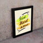 Infidu motivational quotes wall art featuring Work Hard Be Proud on a light white background with light gray flowers and black frame on the wall. the inspiring success