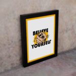 Inspirational quote wall art with "Believe In Yourself" on a white and yellow background and black framed on the wall. Perfect for motivating your workspace.