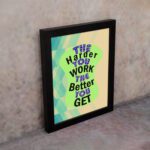 Infidu The Harder You Work The Better You Get wall art with a sandal-colored background green design, and black frame on the wall. Inspiring decor for home offices and workspaces.