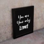 Infidu motivational quotes wall art featuring You Are Your Only Limit on a dark black background and black frame on the wall. Perfect for inspiring your workspace.