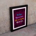 Infidu Bible Wall Art with the text The Lord Remembers Us and Will Bless Us in blue, yellow, and white on a purple background. displayed on the wall in a black frame