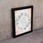 Infidu Set Your Affection On Things Above Bible Wall Art with floral wreath and pink background. displayed on the wall in a black frame