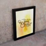 Jesus Christ Bible Wall Art in black script with a yellow cross and watercolor background, framed in black. Perfect Christian home decor. displayed on the wall in a black frame