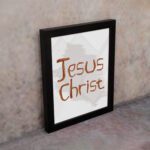 Jesus Christ Bible wall art with hand-drawn brown lettering and a minimalist white-gray watercolor background in a black frame. displayed on the wall in a black frame