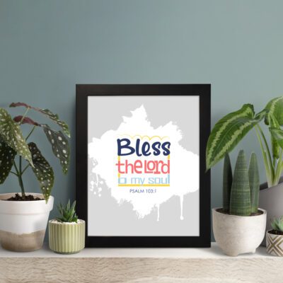 Bless The Lord O My Soul Psalm 103:1 Christian wall art in bold blue and orange, with a light gray background and splash design. displayed on the table in a black frame