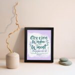 Christian wall art with Getting Wisdom Is The Wisest Thing You Can Do Proverbs 4:7, green text, light purple background, and decorative swirls. displayed on the wall in a black frame