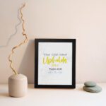 Christian wall art featuring the phrase Your Right Hand Upholds Me in playful fonts with a yellow cursive style and decorative waves. displayed on the wall in a black frame