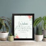 Christian wall art with Proverbs 2:6, featuring "Wisdom" and floral accents on a cream background. displayed on the table in a black frame