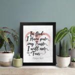 In God I Have Put My Trust, I Will Not Fear Psalm 56:4 Bible Verse Wall Art with pink watercolor arc and black frame. displayed on the table in a black frame