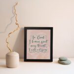 Wall art featuring the quote In God I Have Put My Trust I Will Not Fear from Psalm 56:4 in a bold, playful font. displayed on the wall in a black frame