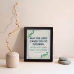 Infidu Christian wall art featuring Psalm 115:14 with bold text, green highlights, and leaf designs on a light gray background. displayed on the wall in a black frame