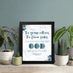 Christian wall art with the verse from Isaiah 40:8, featuring floral details and a textured white background. displayed on the table in a black frame