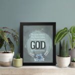 Isaiah 40:8 Christian wall art with light gray and white text on a muted blue background, featuring "GOD" in bold letters. displayed on the table in a black frame