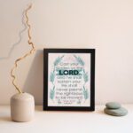 Cast Your Burden on the Lord Psalm 55:22 Christian Wall Art with palm leaf accents and turquoise text on a beige background. displayed on the wall in a black frame