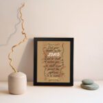 Christian wall art featuring Psalm 55:22, with a warm brown background, dark text, and elegant scrollwork. Perfect for home decor. displayed on the wall in a black frame