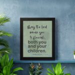 Christian wall art with Psalm 115:14 Bible verse on a light green and gray background with black font and white frame displayed on the floor