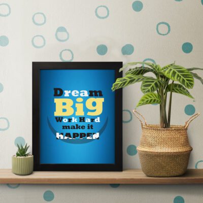 Infidu Dream Big Work Hard Make It Happen wall art with a blue background white, yellow, and black text, and a black frame on the table. Inspiring decor for home offices and workspaces.