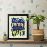 Infidu motivational quotes wall art featuring Together Everyone Achieves More on a white background with a navy blue design and gray shadow and black frame on the table. the inspiring teamwork