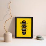 Infidu The Harder You Work The Better You Get wall art with a yellow background and dark yellow and white text with black shadow and black frame displayed on the wall. Inspiring decor for home offices and workspaces.