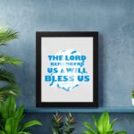 Wall art featuring the text The Lord Remembers Us And Will Bless Us in bold blue on a soft gray background. displayed on the wall in a black frame